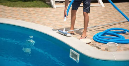 man with pool maintenance equipment